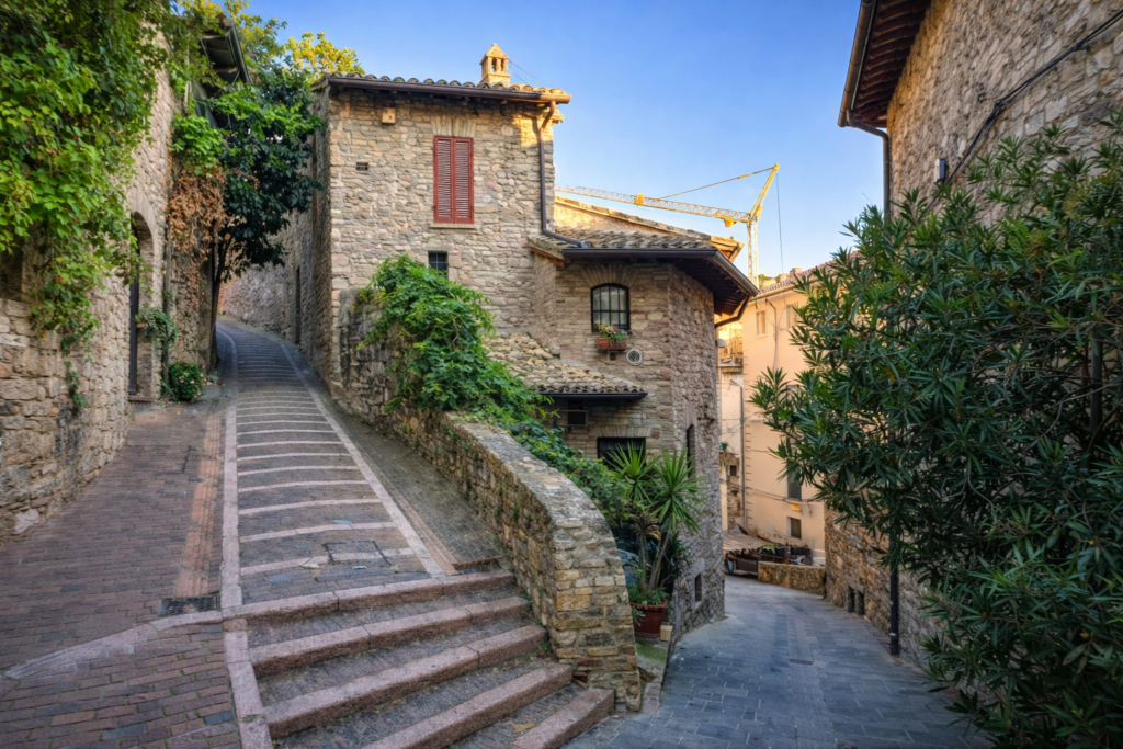 Kamienna uliczka ze schodami w sycylijskim miasteczku z roślinnością